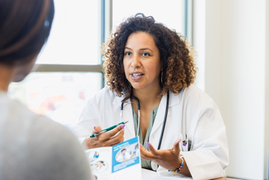 A clinician engages in a thoughtful discussion with her patient, focusing on their health needs in a bright, welcoming environment.